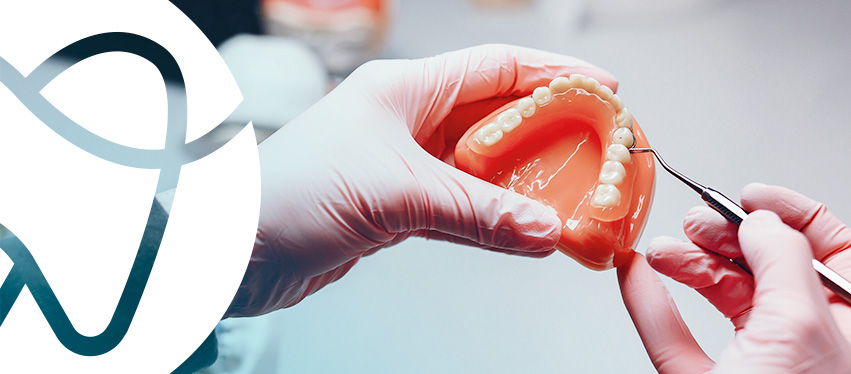 Prótese total sendo ajustada com instrumento no laboratório de prótese da Consulab